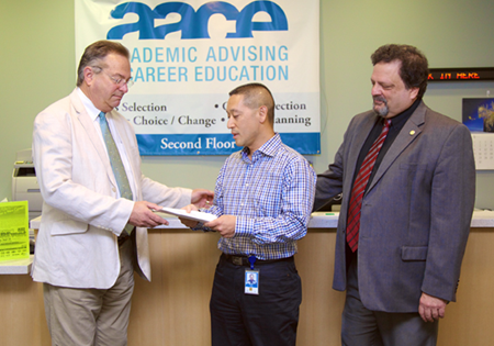 CSUEB grad Scott Louie '87 presents a check from his employer, Chevron, to AACE Director Larry Bliss (L) and Provost Jim Houpis at CSUEB. (By: Garvin Tso)